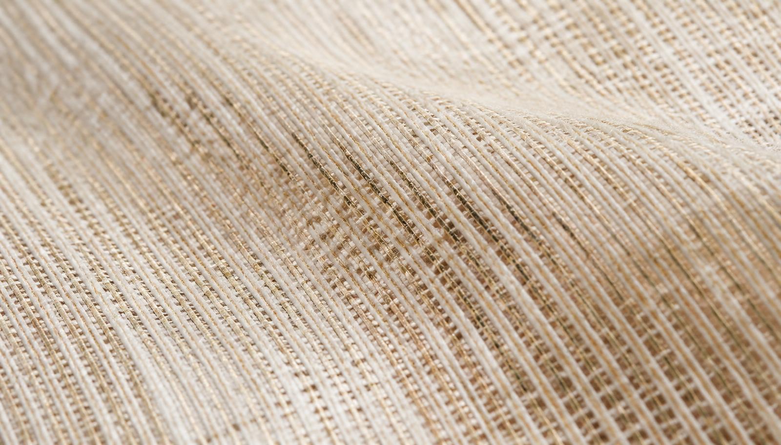Macro detail of a handwoven natural linen textile in cream and gold